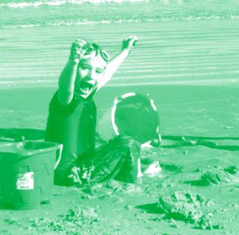 A boy is playing in the sand with a bucket.