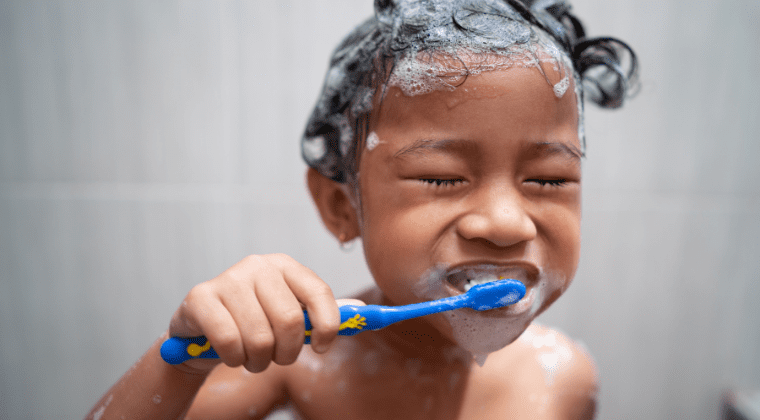 A young girl prioritizing good hygiene and demonstrating self-worth as she diligently brushes her teeth with a toothbrush.