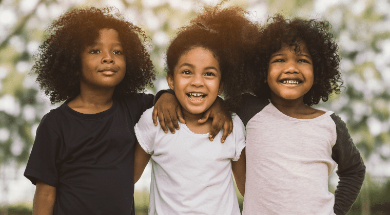 A group of young black children, displaying friendship and doing the right thing, smile together.